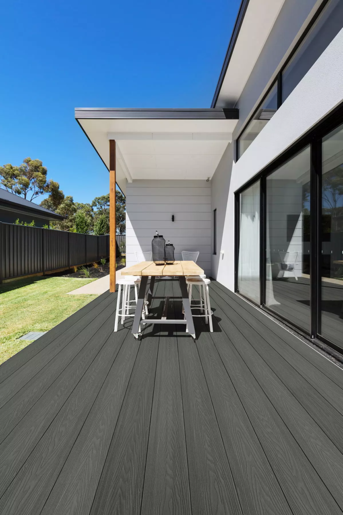 A dark gray composite deck idea with an outdoor dining table with high-chairs