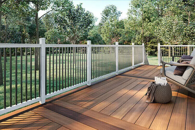 A small outdoor patio deck with mixed brown composite decking materials and picket railin