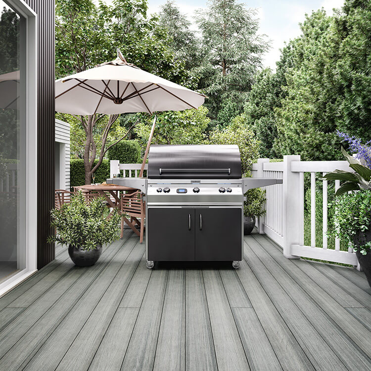 A beach gray composite deck with a grill and outdoor dining table
