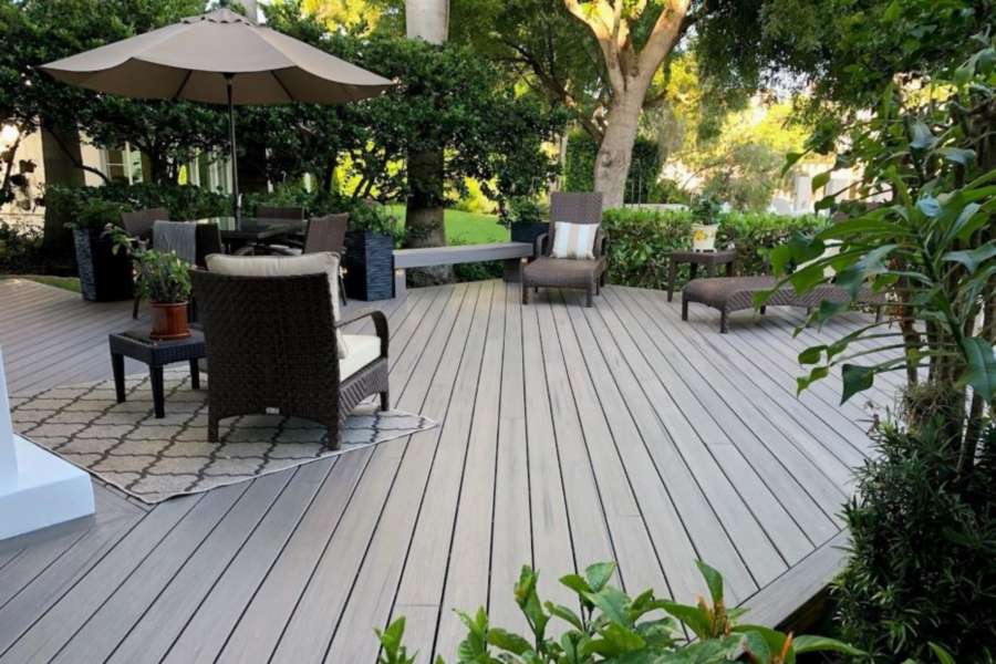 A modern-looking, no maintenance deck made of a composite decking material in a backyard.