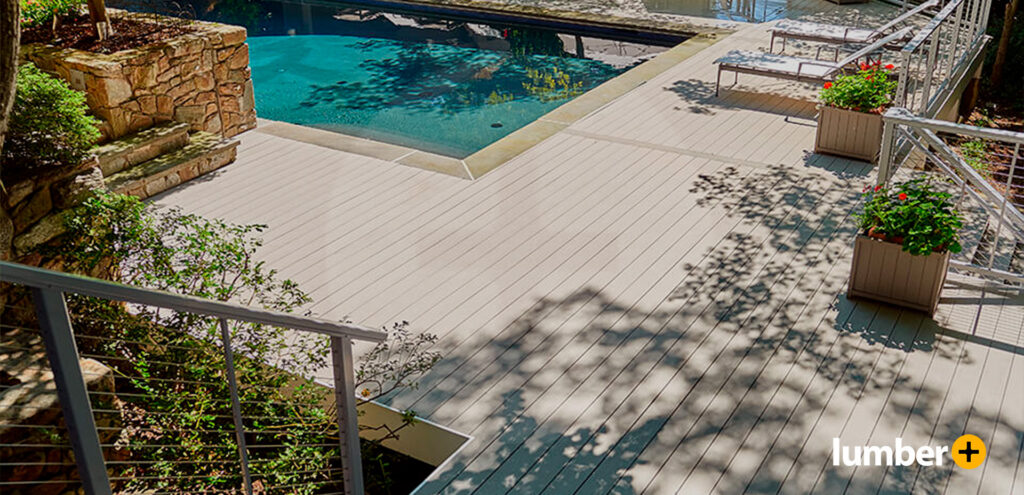 Light beige decking around an outdoor pool and potted plants.