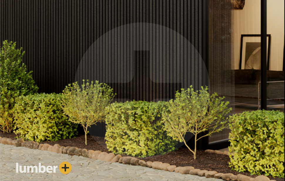 Dark textured cladding on the exterior walls of a house with shrubbery in front.