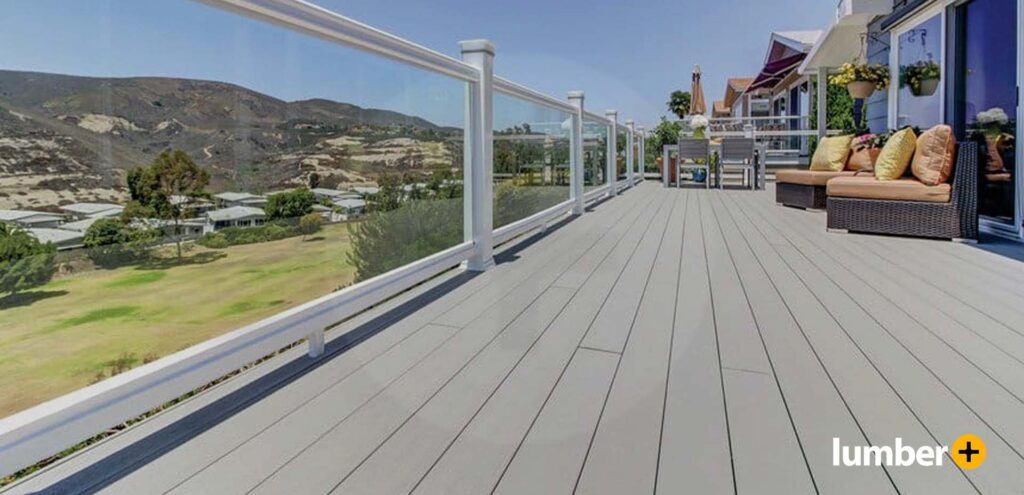A modern gray deck that is up to code that overlooks a large grass field.