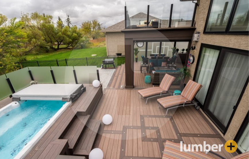 A luxury deck idea for the backyard of a home with lounge chairs and a hot tub.