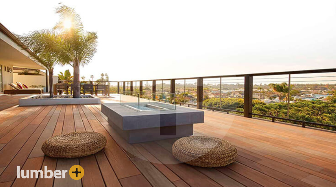 A large deck made out of Vintage® wood that overlooks a river and forest.