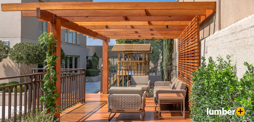 Red wood pergola with seating outside a courtyard.