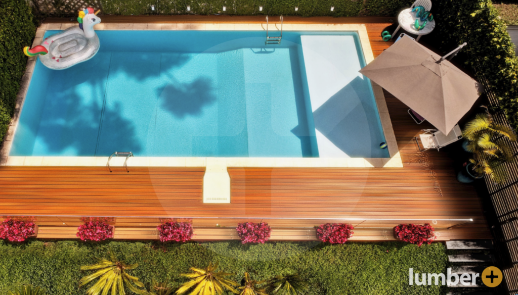 Multi-toned wood decking offers a stylish ground level deck idea by the pool.