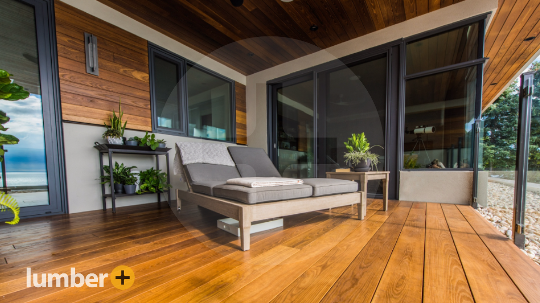 Golden wood decking warms this elevated patio, blending indoors and out.