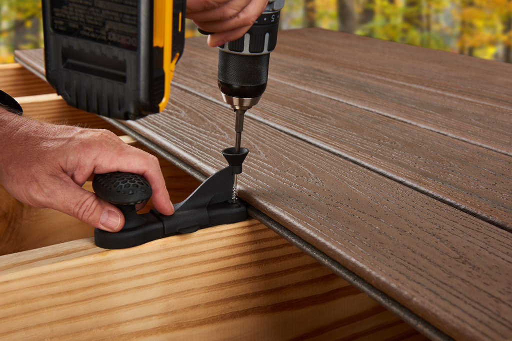 A worker uses specialized tools to fasten Trex composite decking into place.