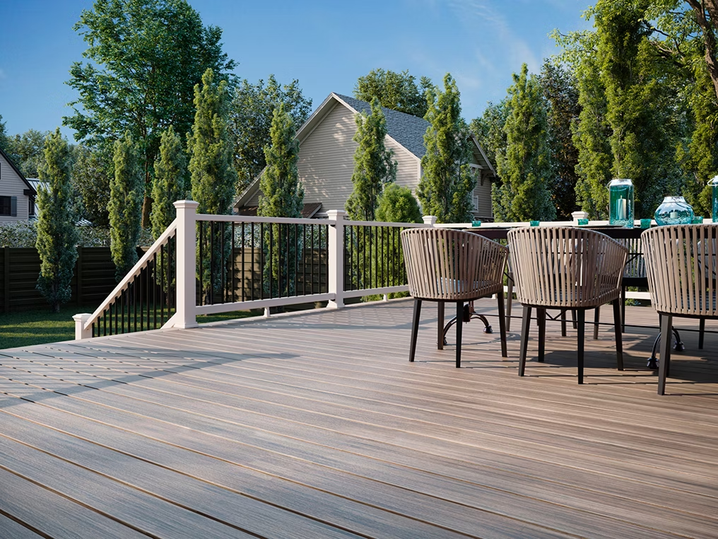 Raised patio featuring Honey Grove decking with white railing and black rod infill, creating a sophisticated outdoor retreat.