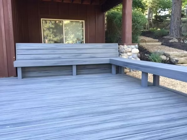 Trex Transcend® Island Mist patio deck with a light gray bench, showcasing Trex deck bench ideas for a modern rustic outdoor space.