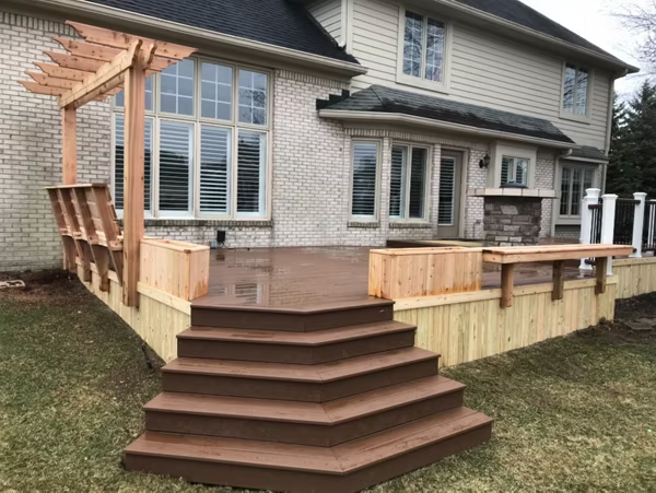 Dark brown patio deck with Saddle Trex decking, treated pine skirting, planter boxes, trellis, and a floating bench for a rustic modern design.