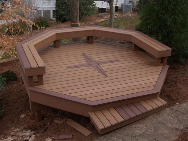 Two-toned hexagon deck with light and dark brown tones, a built-in bench, and Trex dark brown accents.