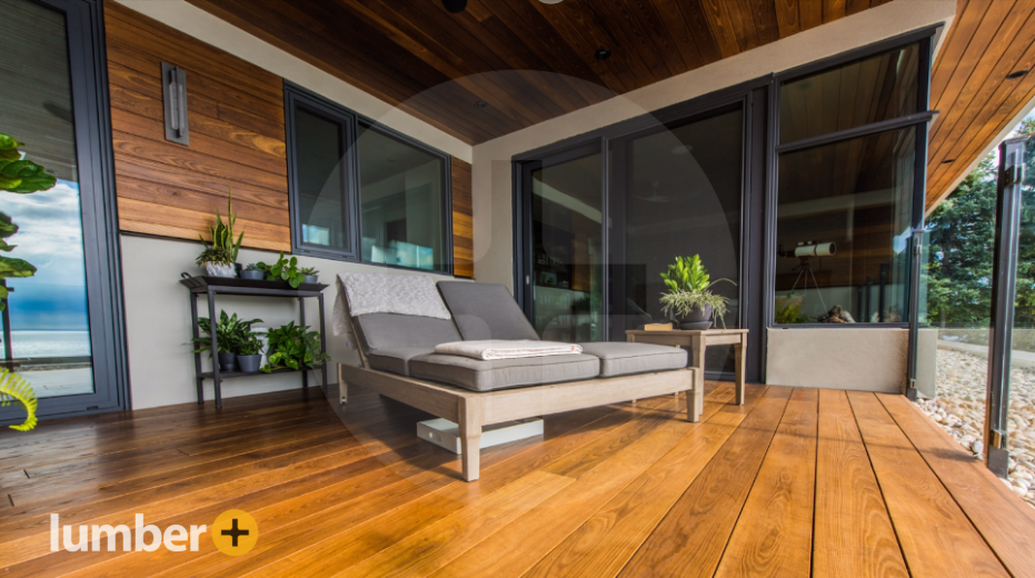 The outdoor patio of a house with wood siding. 