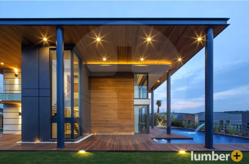 Modern home with Thermowood Ayous cladding and decking, warm lights, and sleek poolside design.