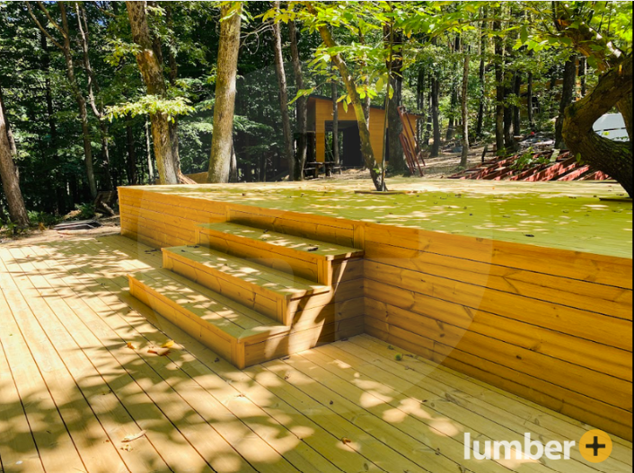 Thermowood Pine deck and stairs surrounded by trees and sunlight.
