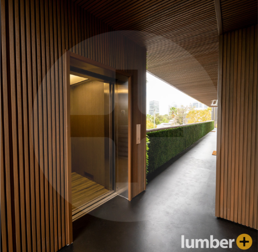 An image of a modern building hallway with vertical wood slat siding and an open elevator.