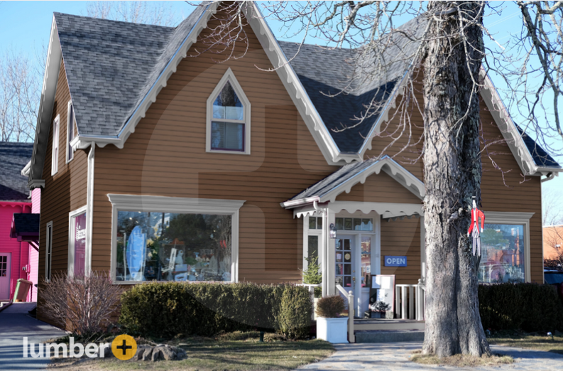 An image of a cottage with light brown vinyl siding. 